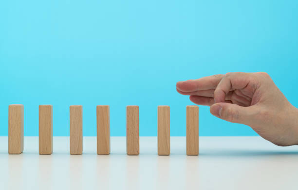 istock Human finger pushing domino pieces 2175870648