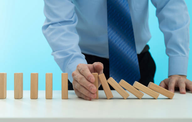 istock Businessman hand stopping the dominos falling 2175870655