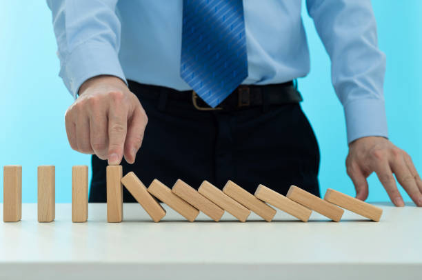 istock Businessman hand stopping the dominos falling 2175870665