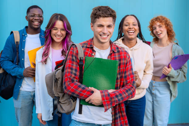 istock Group of smiling students standing together outdoors with backpacks and books 2175870949