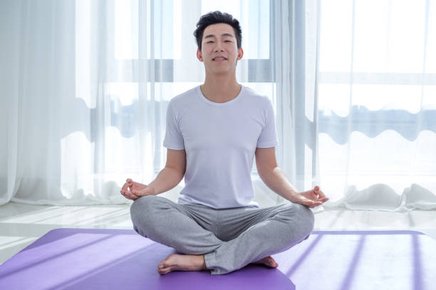 istock young man do yoga in room 2175872567
