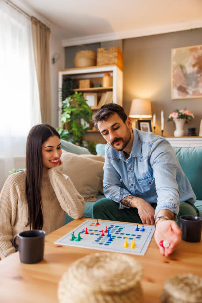 Beautiful multi-ethnic couple playing ludo board game
