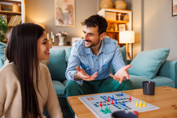 istock Couple playing ludo board game while relaxing at home 2175873266