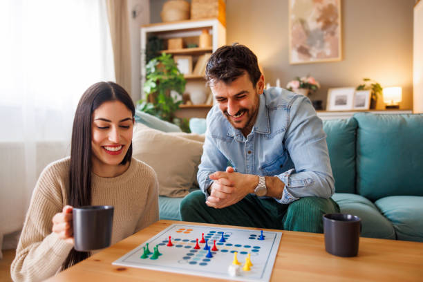 istock Couple spending leisure time at home playing ludo board game 2175873386