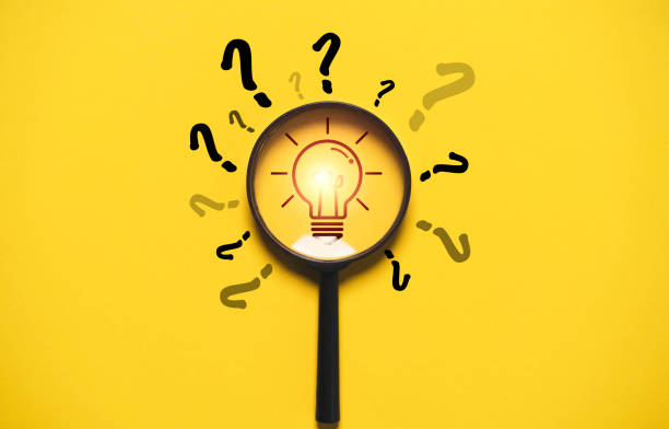 istock Glowing light bulb inside magnifier glass among question mark for focus and concentrate of creative thinking idea and problem solving concept. 2175876441