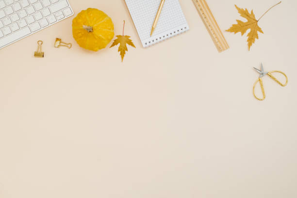 istock Flat lay home office desk. Freelancer or blogger workplace with computer, yellow pumpkins, fallen leaves, scissors, notepad, ruler and pen on a light beige background with copy space. Autumn composition top view. 2175879095