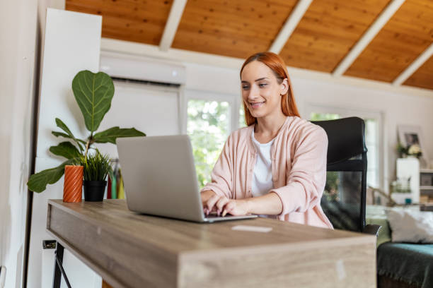 istock Woman enjoying remote work on laptop, smiling warmly. 2175879656