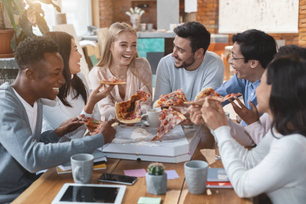 istock Happy people eating pizza at office during lunch time 2175880551