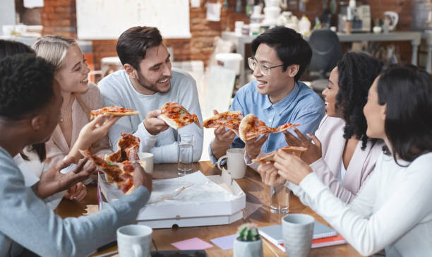 istock Friendly international team enjoying pizza together in office 2175880611