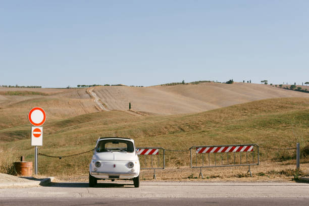 San Quirico D'Orcia, Siena, Italy - 8/25/2024: typical Italian car parked in the hills of Val D'Orcia in a sunny day