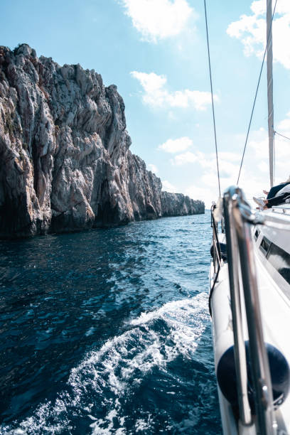 A sailboat passes a cliff in Croatia.