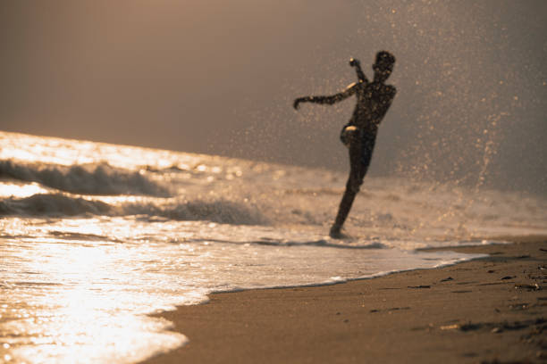 istock Happy boy playing with waves at the beach 2175887802