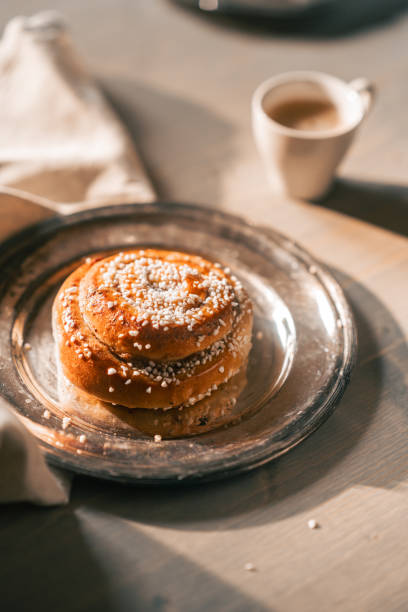 Delicious cinnamon buns with sugar on rustic plate and espresso coffee