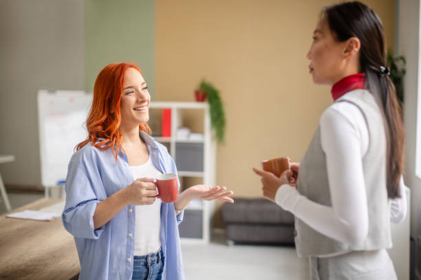 istock Red-haired woman smiling and holding mug in office 2175892145
