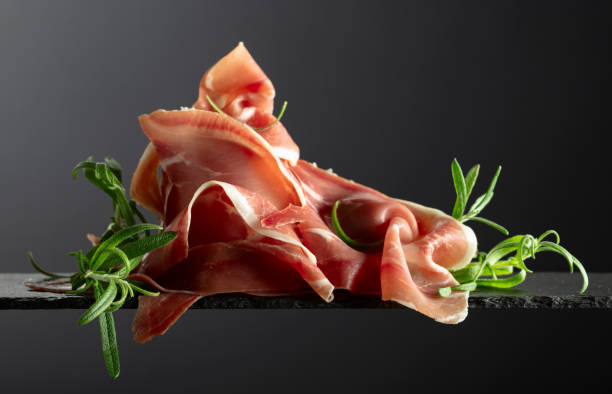istock Prosciutto with rosemary on a black background. 2175893705