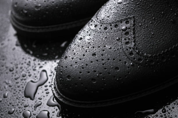 istock Black leather brogue boots in water droplets 2175895997
