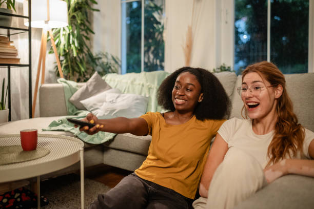istock Two women laughing together in cozy living setting. 2175897988