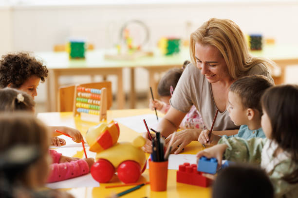 istock Teacher drawing whit children in kindergarten 2175898233