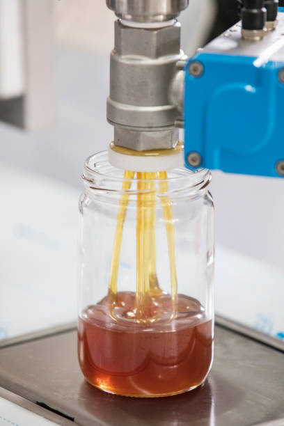 istock Filling empty jars with fresh honey in factory. 2175900418