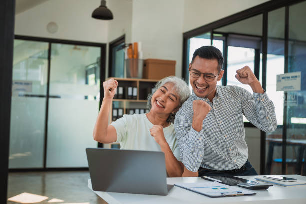 istock Senior female specialist talking on the phone, writing notes while new colleague is working on laptop, teamwork or multitasking, manager in meeting, financial accounting concept 2175900818