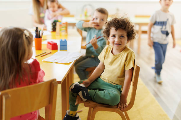 istock Little boy sitting on a chair while drawing in kindergarten 2175901459