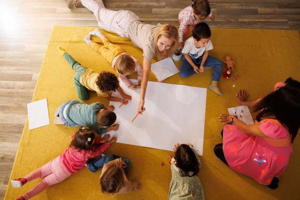 istock Kindergarten teachers draw with children 2175902777