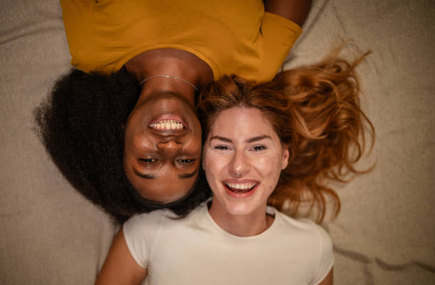 istock Two friends laughing together on a cozy blanket 2175903897