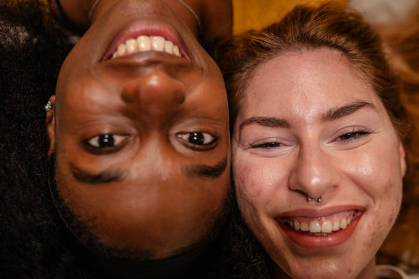 istock Two friends lying and smiling in warm light portrait. 2175903994