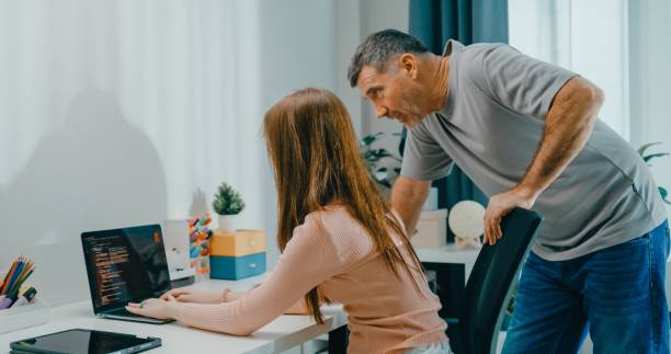 istock Senior father helps his daughter with her coding homework on laptop, family support and e-learning at home. Lifestyle family. 2175904917