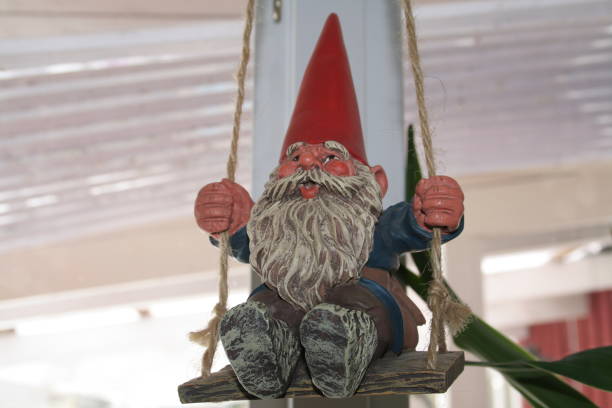 two toys santa claus and clown sitting on a gray stump in summer nature