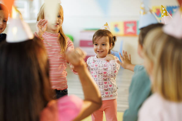 Group of happy kids having fun on children's birthday in playroom