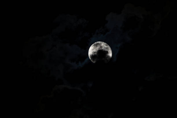 Full September Supermoon against the black cloudy night sky