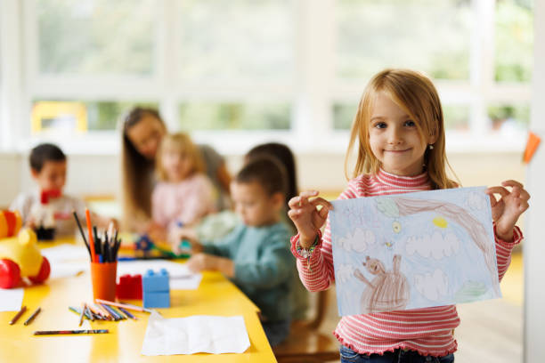 istock Girl holding her drawing in kindergarten 2175911728