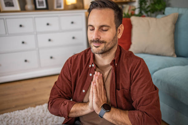 istock Middle aged man sitting on floor practicing guided meditation at home, relaxing body and mind concept 2175916404