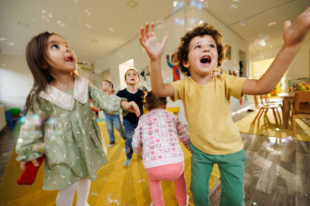 istock Children having fun playing whit soap bubbles indoors 2175924694