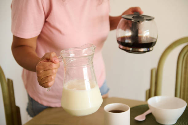 istock Person preparing morning coffee with milk in cozy kitchen 2175927490