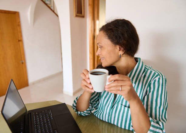 istock Woman enjoying coffee while working on a laptop at home 2175927511