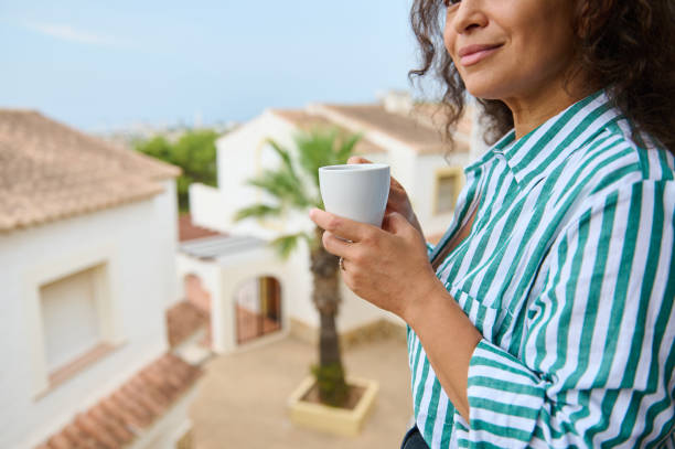 istock Woman enjoying coffee on a sunny balcony with a view 2175927555