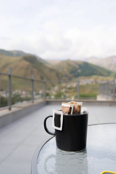 Drip coffee bag with ground coffee in cup. Making freshly coffee in mug.