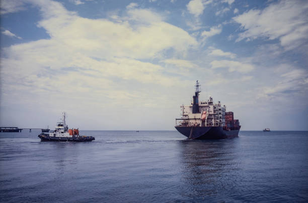 istock Tugboat maneuvers a container ship in the port. 2175928065