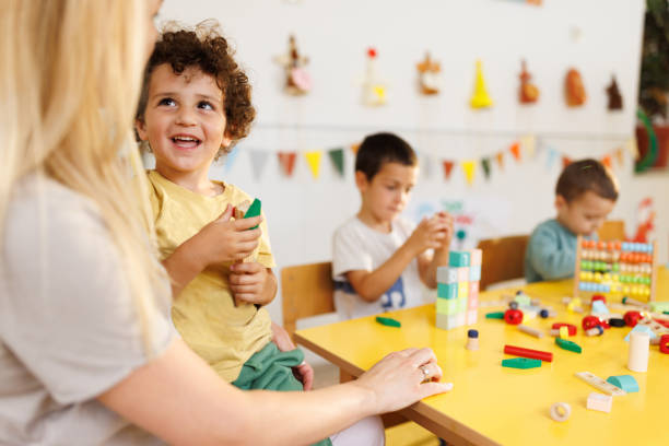 istock Boy plays with teacher in kindergarten 2175932341