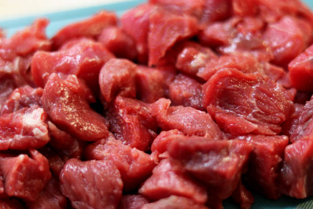 istock Close up of raw beef meat chopped in small cubes on cutting board 2175934021