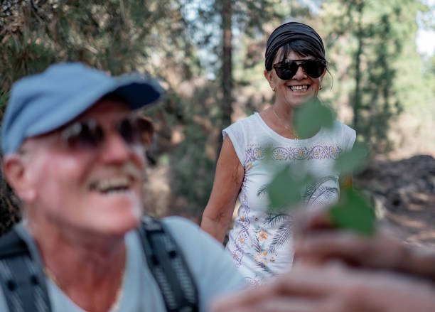istock Defocused old smiling caucasian senior man in outdoors excursion offering a small brunch to a lady 2175941552