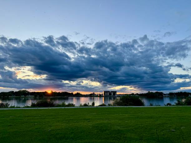 Distant wide angle view of sun disappearing behind the trees near the Fox River Trail in Green Bay Wisconsin