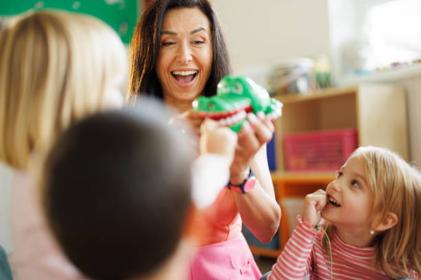 istock Woman having fun while playing with children in playroom 2175942977