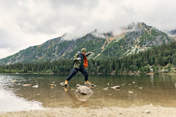 Teenage hiker walking on stones in the Popradské pleso in the High Tatra Mountains Family is hiking in the High Tatra Mountains, Slovakia. Teenage boy is walking on the stones in the Popradské pleso lake. Cold and overcast autumn day.
Shot with Canon R5 high tatras stock pictures, royalty-free photos & images