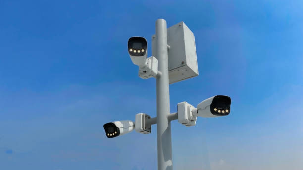 istock Old security camera or CCTV sits on a pole with a sky background 2175957654