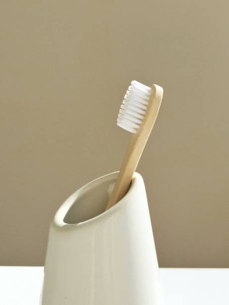 istock Eco-friendly bamboo toothbrush in a white cup 2175960485