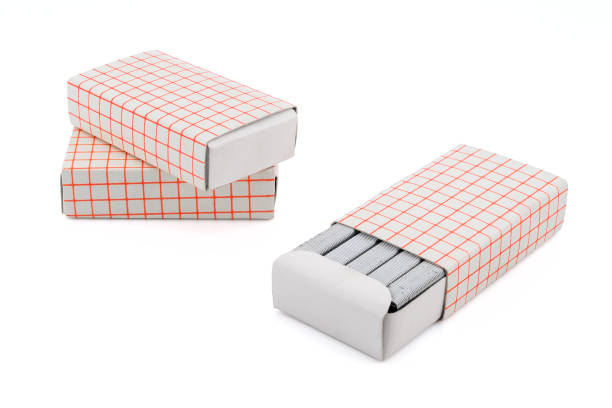 metal sharp staples for office stapler and cardboard packaging box for staples, close-up, side view, isolated on white background