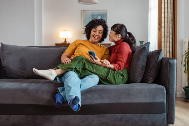 istock Lesbian couple relaxing at home and using phone 2175967977